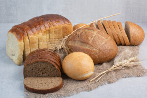 Various homemade bread on burlap with wheat